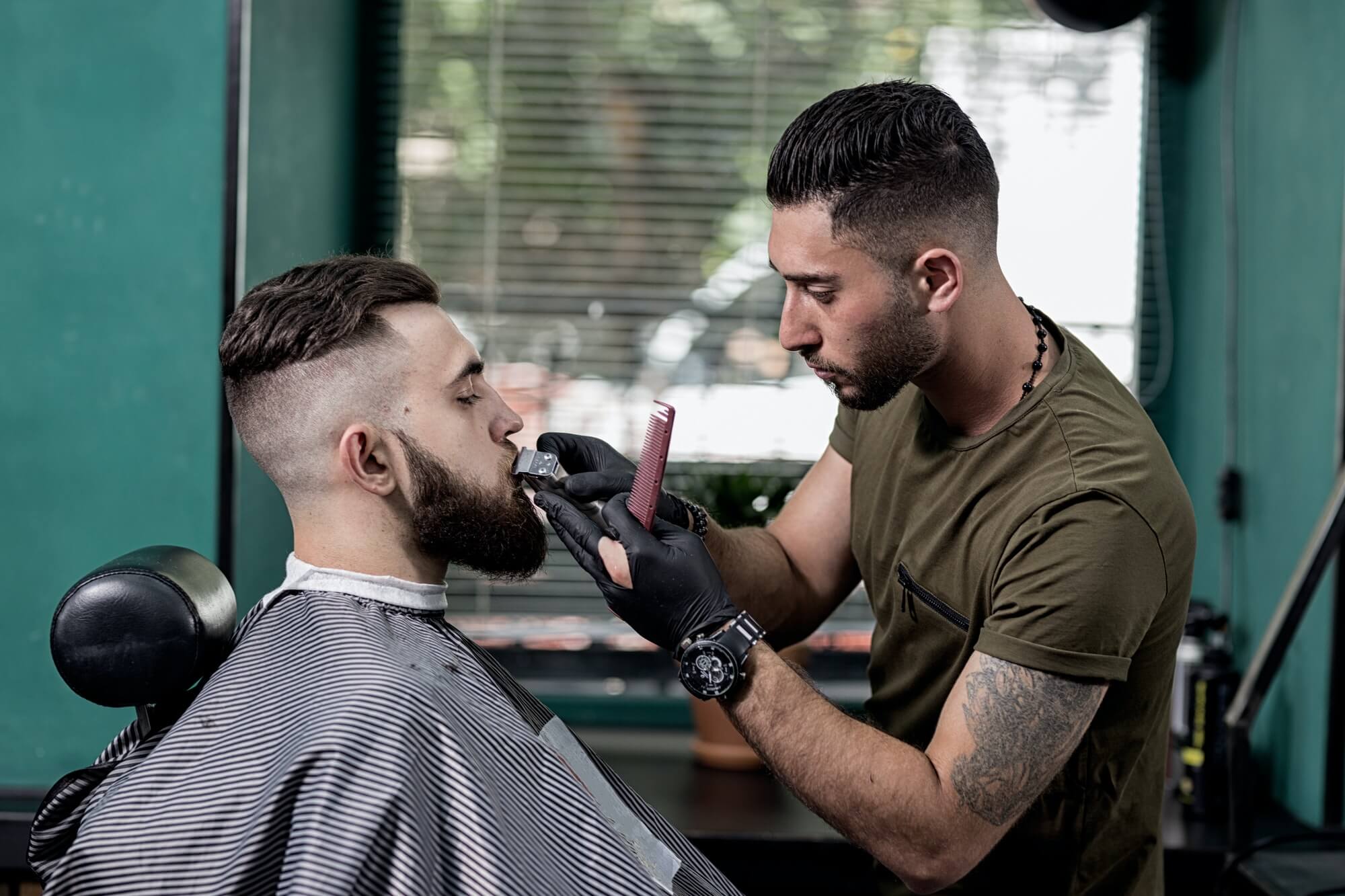 barber-trims-mustache-of-dark-haired-stylish-man-at-a-barbershop.jpg